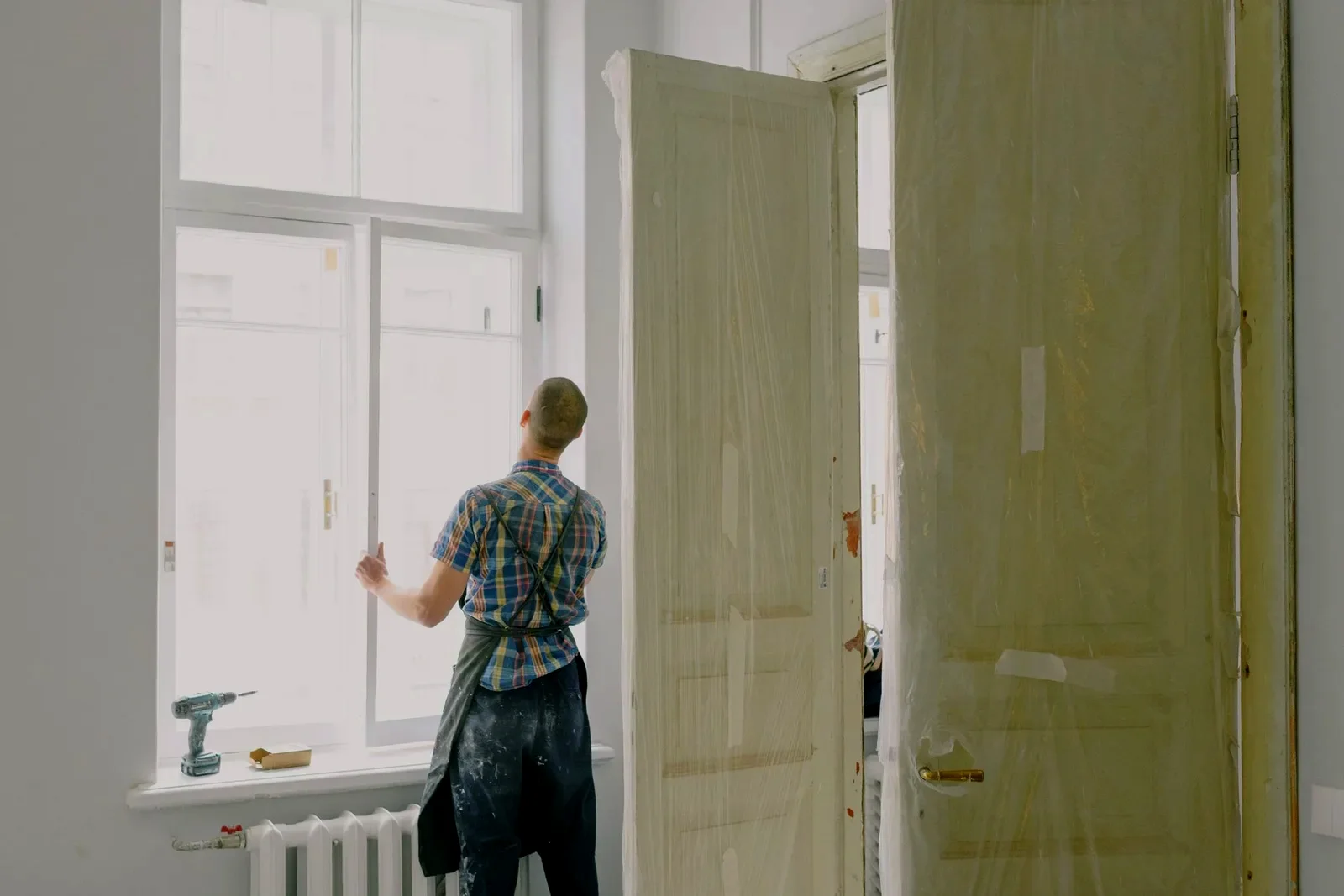 Maintenance technician servicing interior doors and windows during a commercial facility repair visit